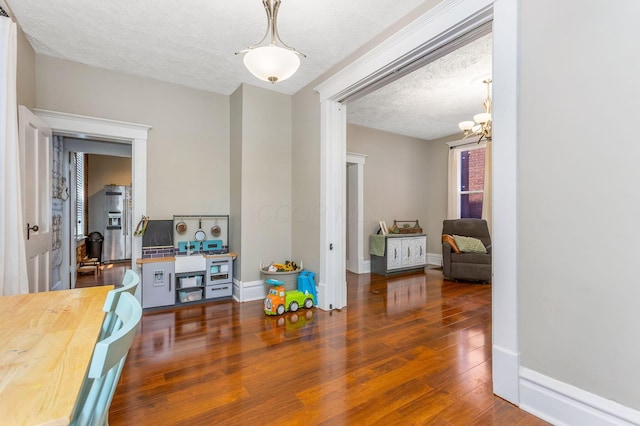 141 E 5th Ave, Lancaster, OH 43130 - dining room featuring a textured ceiling, wood finished floors, a chandelier, and baseboards