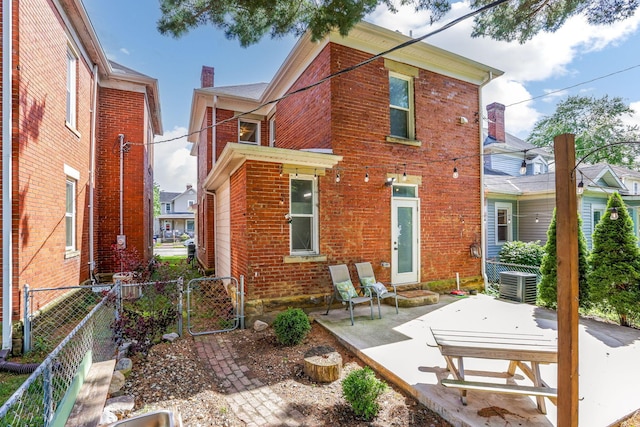 141 E 5th Ave, Lancaster, OH 43130 - rear view of house with brick siding, central AC unit, a patio area, and a chimney