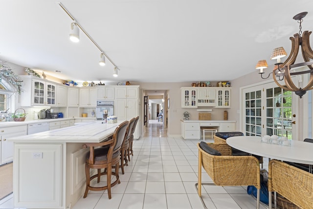 8039 Crossgate Ct S, Dublin, OH 43017 - kitchen featuring a chandelier, white appliances, light countertops, light tile patterned floors, and a kitchen island