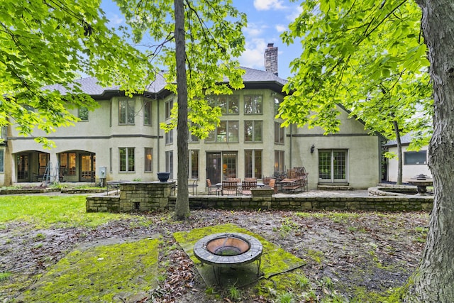 8039 Crossgate Ct S, Dublin, OH 43017 - rear view of property with an outdoor fire pit, a patio area, stucco siding, and a chimney