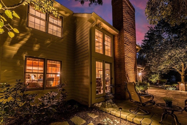 5714 Zetland Ct, Dublin, OH 43017 - back of property at dusk featuring a chimney and a patio area
