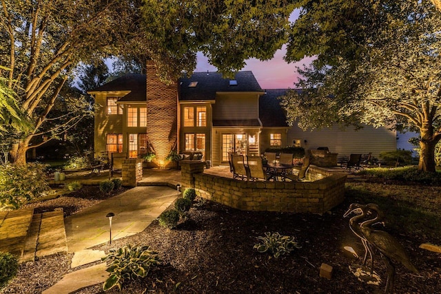 5714 Zetland Ct, Dublin, OH 43017 - back of property at dusk featuring a chimney and a patio area
