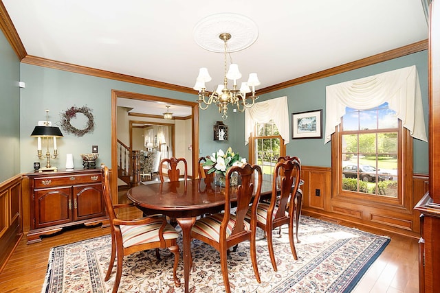5714 Zetland Ct, Dublin, OH 43017 - dining room featuring a chandelier, wainscoting, crown molding, stairs, and light wood finished floors