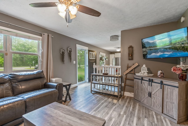 5250 Summit Rd SW, Pataskala, OH 43062 - living area with light wood-type flooring, plenty of natural light, a textured ceiling, baseboards, and a ceiling fan
