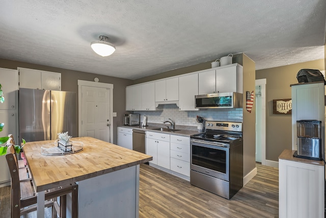 5250 Summit Rd SW, Pataskala, OH 43062 - kitchen with appliances with stainless steel finishes, a sink, backsplash, white cabinets, and a textured ceiling