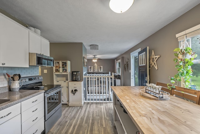5250 Summit Rd SW, Pataskala, OH 43062 - kitchen with stainless steel appliances, wood counters, light wood-type flooring, backsplash, and white cabinetry
