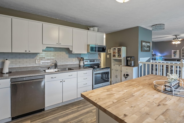 5250 Summit Rd SW, Pataskala, OH 43062 - kitchen featuring appliances with stainless steel finishes, a sink, butcher block countertops, dark wood-style flooring, and tasteful backsplash