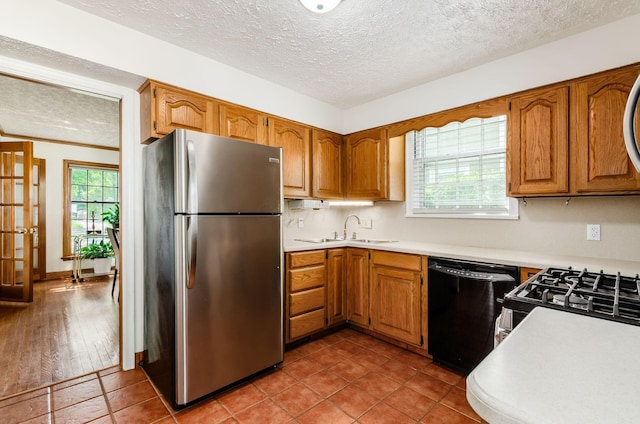 193 N Remington Rd, Columbus, OH 43209 - kitchen with black appliances, a sink, a textured ceiling, light countertops, and brown cabinetry