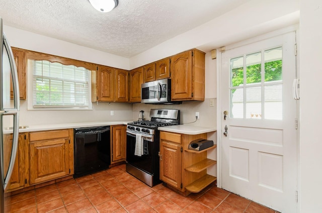 193 N Remington Rd, Columbus, OH 43209 - kitchen with appliances with stainless steel finishes, light countertops, light tile patterned flooring, brown cabinets, and a textured ceiling