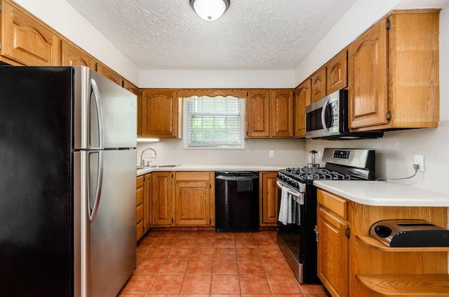 193 N Remington Rd, Columbus, OH 43209 - kitchen with appliances with stainless steel finishes, a sink, a textured ceiling, brown cabinetry, and light countertops