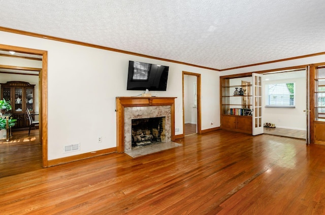 193 N Remington Rd, Columbus, OH 43209 - unfurnished living room featuring wood finished floors, a textured ceiling, baseboards, a fireplace, and french doors
