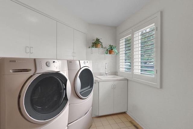 744 Old Oak Trce, Columbus, OH 43235 - laundry area featuring washing machine and clothes dryer, cabinet space, light tile patterned floors, and baseboards