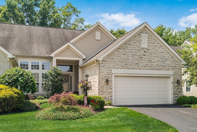 165 Tinley Park Cir, Delaware, OH 43015 - view of front of property featuring stone siding, asphalt driveway, roof with shingles, and a garage
