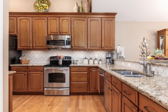 165 Tinley Park Cir, Delaware, OH 43015 - kitchen with stainless steel appliances, light stone countertops, tasteful backsplash, and brown cabinets