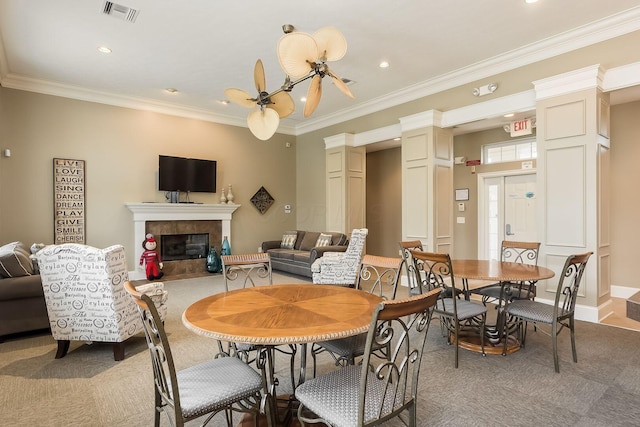 165 Tinley Park Cir, Delaware, OH 43015 - dining space featuring ornate columns, light colored carpet, recessed lighting, a tiled fireplace, and ornamental molding