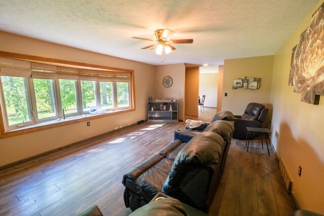 9442 Mitchell Dewitt Rd, Plain City, OH 43064 - living area with ceiling fan, a textured ceiling, wood finished floors, and baseboards