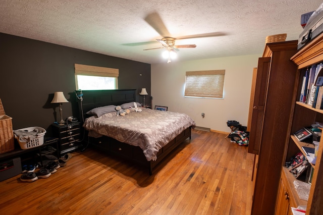 9442 Mitchell Dewitt Rd, Plain City, OH 43064 - bedroom featuring light wood-style flooring, baseboards, a textured ceiling, and a ceiling fan