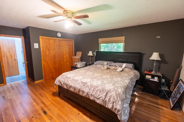 9442 Mitchell Dewitt Rd, Plain City, OH 43064 - bedroom with wood finished floors, a closet, baseboards, a ceiling fan, and a textured ceiling
