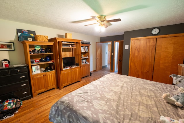 9442 Mitchell Dewitt Rd, Plain City, OH 43064 - bedroom with light wood-style floors, a textured ceiling, a ceiling fan, and a closet