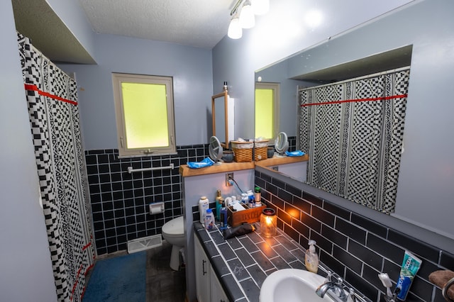 9442 Mitchell Dewitt Rd, Plain City, OH 43064 - bathroom with tile walls, toilet, a shower with shower curtain, a wainscoted wall, and a textured ceiling