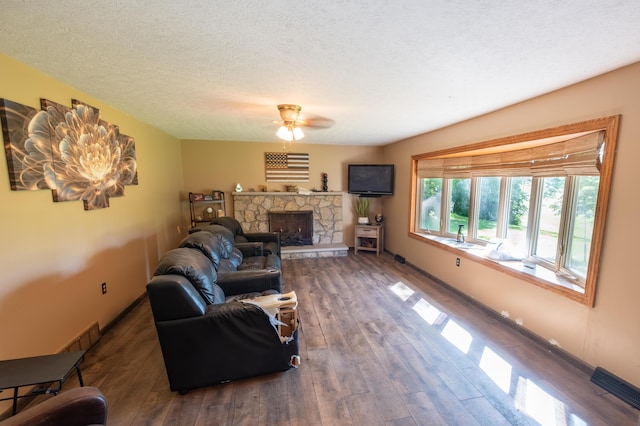 9442 Mitchell Dewitt Rd, Plain City, OH 43064 - living area with ceiling fan, hardwood / wood-style floors, a fireplace, baseboards, and a textured ceiling