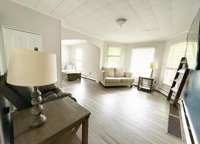 313 E Auburn Ave, Bellefontaine, OH 43311 - living area featuring a baseboard radiator, arched walkways, and wood finished floors