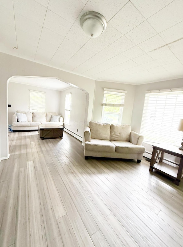 313 E Auburn Ave, Bellefontaine, OH 43311 - living room featuring arched walkways, a baseboard heating unit, wood finished floors, and baseboards