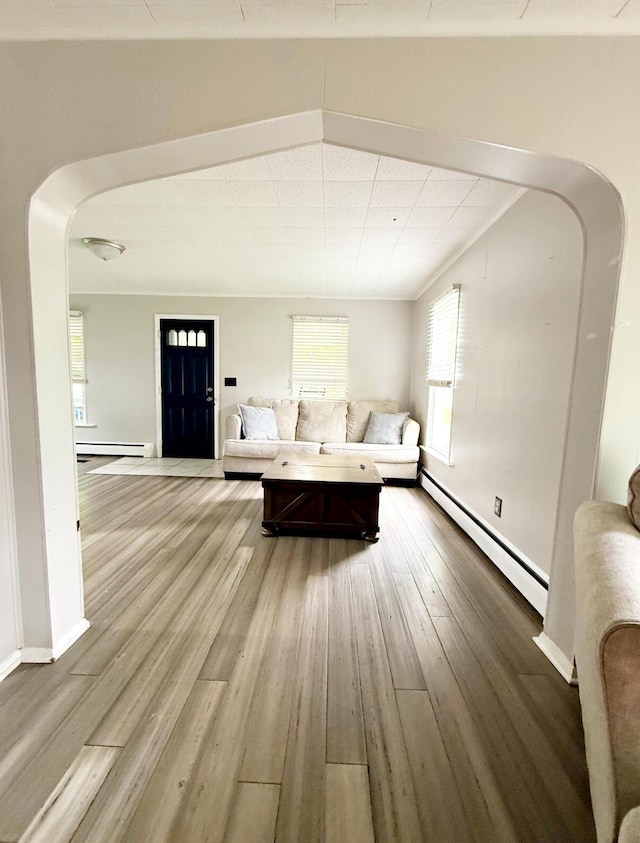 313 E Auburn Ave, Bellefontaine, OH 43311 - living area featuring baseboard heating, a baseboard radiator, arched walkways, wood finished floors, and baseboards