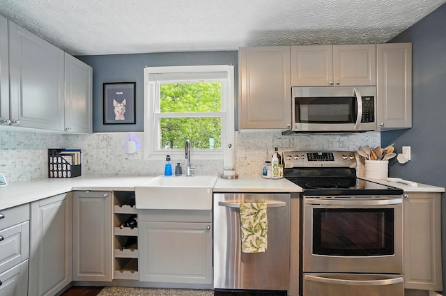 2216 Smoky View Blvd, Powell, OH 43065 - kitchen featuring stainless steel appliances, a sink, tasteful backsplash, light countertops, and a textured ceiling