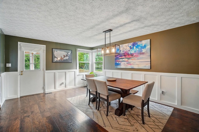 2216 Smoky View Blvd, Powell, OH 43065 - dining area featuring a wainscoted wall, a decorative wall, wood finished floors, a chandelier, and a textured ceiling