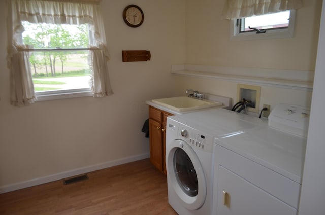 5810 Bickle Church Rd NW, Pickerington, OH 43147 - laundry area with washer and clothes dryer, plenty of natural light, cabinet space, and light wood-style flooring
