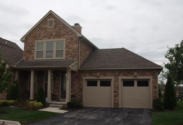 3750 Echo Pl, Powell, OH 43065 - view of front of house with driveway, an attached garage, a chimney, and covered porch