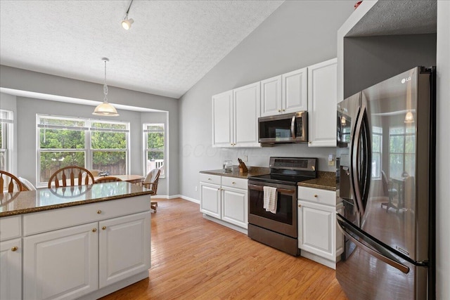 2880 Longridge Way, Grove City, OH 43123 - kitchen featuring stainless steel appliances, white cabinets, a textured ceiling, lofted ceiling, and light wood-style floors