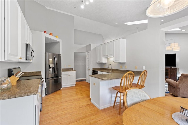 2880 Longridge Way, Grove City, OH 43123 - kitchen with stainless steel appliances, light wood-type flooring, dark countertops, a peninsula, and white cabinetry