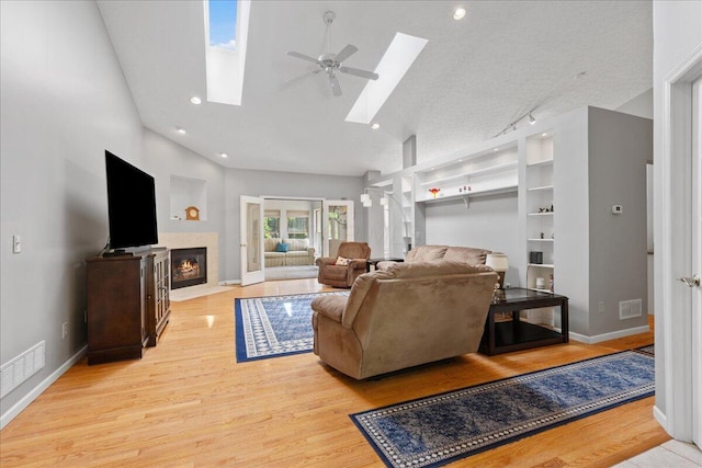 2880 Longridge Way, Grove City, OH 43123 - living room featuring a skylight, ceiling fan, light wood-style floors, a fireplace with flush hearth, and lofted ceiling
