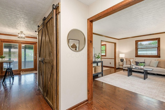 6392 Hilltop Ave, Reynoldsburg, OH 43068 - corridor featuring a textured ceiling, a barn door, dark wood-type flooring, ornamental molding, and baseboards