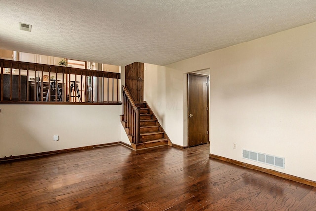 6392 Hilltop Ave, Reynoldsburg, OH 43068 - unfurnished room with hardwood / wood-style flooring, baseboards, a textured ceiling, and stairs