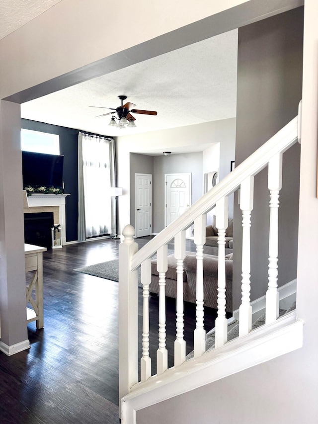 1522 E Quail Run Dr, Newark, OH 43055 - staircase featuring wood finished floors, ceiling fan, baseboards, and a fireplace