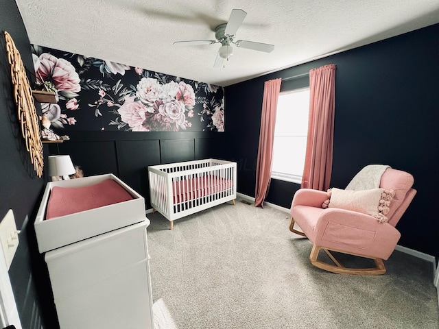 1522 E Quail Run Dr, Newark, OH 43055 - carpeted bedroom featuring a nursery area, a textured ceiling, ceiling fan, and wainscoting