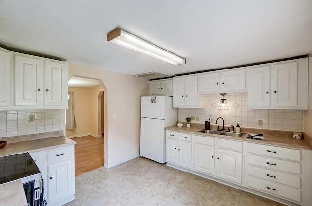 1036 State Route 247, Hillsboro, OH 45133 - kitchen with freestanding refrigerator, arched walkways, backsplash, electric range, and white cabinets