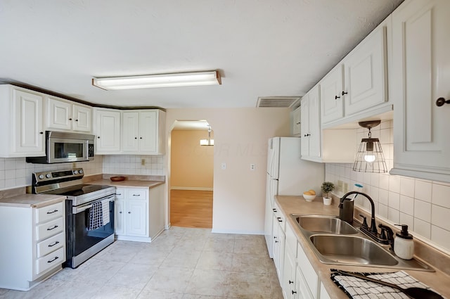 1036 State Route 247, Hillsboro, OH 45133 - kitchen with stainless steel appliances, decorative backsplash, white cabinetry, and light countertops