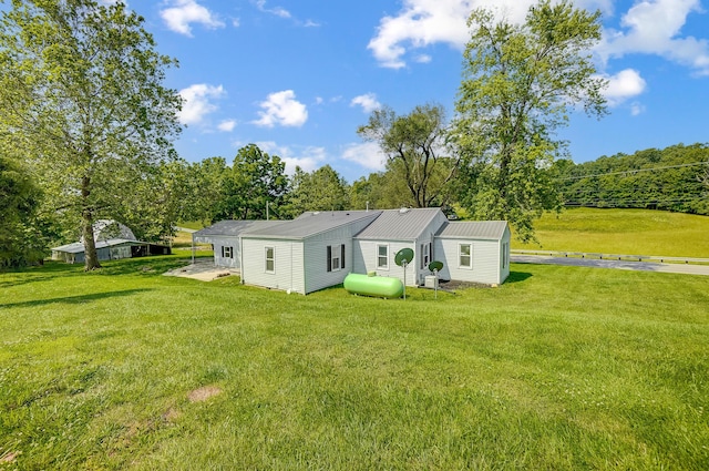 1036 State Route 247, Hillsboro, OH 45133 - back of house with a yard, a metal roof, and view of wooded area