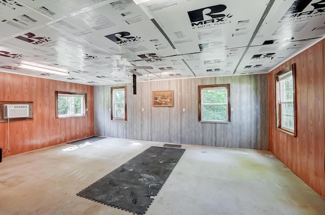 1036 State Route 247, Hillsboro, OH 45133 - empty room with healthy amount of natural light, concrete flooring, an AC wall unit, and wood walls