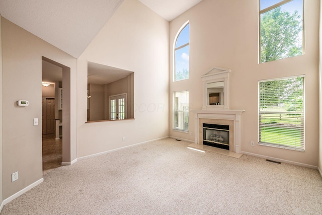56 Dellenbaugh Loop, Etna, OH 43062 - unfurnished living room with high vaulted ceiling, carpet flooring, baseboards, and a high end fireplace