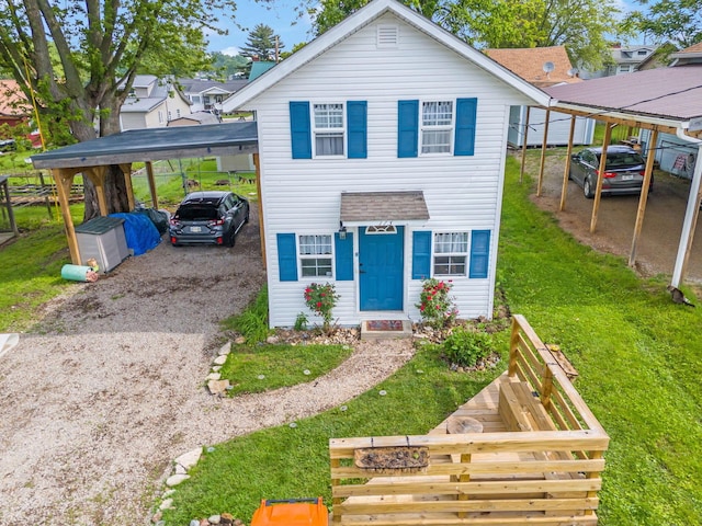 173 Highland Ave, Buckeye Lake, OH 43008 - view of front of house with a carport, a front lawn, and gravel driveway