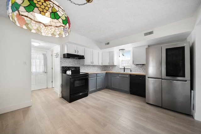 173 Highland Ave, Buckeye Lake, OH 43008 - kitchen with black appliances, a sink, under cabinet range hood, light wood-style floors, and decorative backsplash