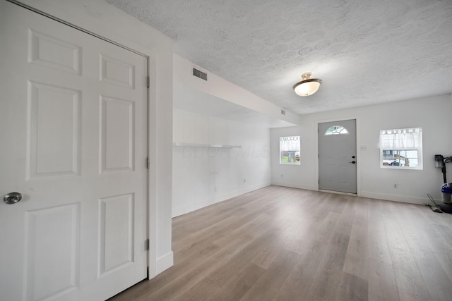 173 Highland Ave, Buckeye Lake, OH 43008 - entryway with a textured ceiling, baseboards, wood finished floors, and a wood stove