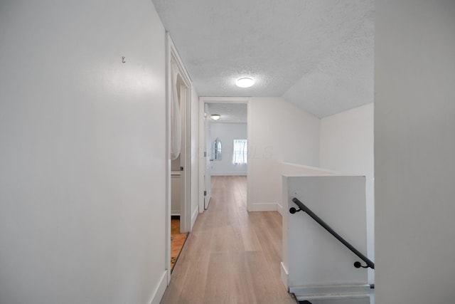173 Highland Ave, Buckeye Lake, OH 43008 - hall with an upstairs landing, a textured ceiling, light wood-style flooring, baseboards, and lofted ceiling