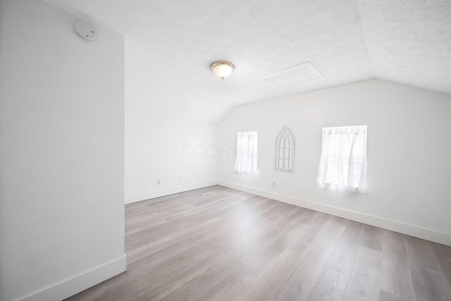 173 Highland Ave, Buckeye Lake, OH 43008 - bonus room featuring vaulted ceiling, baseboards, attic access, wood finished floors, and a textured ceiling
