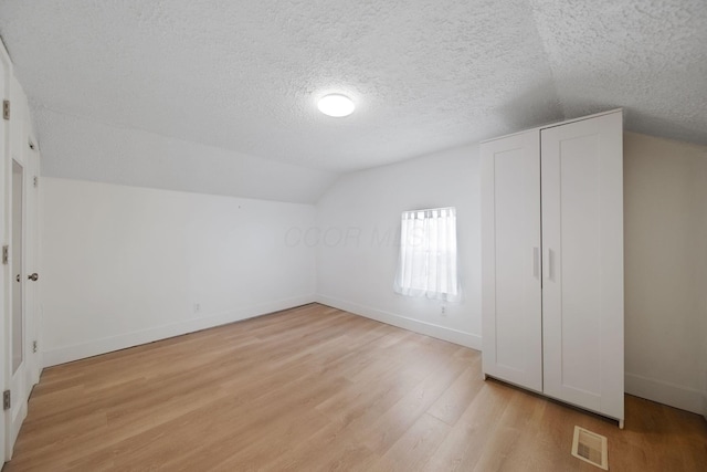 173 Highland Ave, Buckeye Lake, OH 43008 - bonus room featuring a textured ceiling, baseboards, light wood finished floors, and lofted ceiling